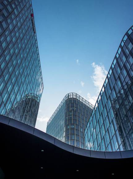 A vertical shot of modern office buildings with big reflective windows under the sunlight